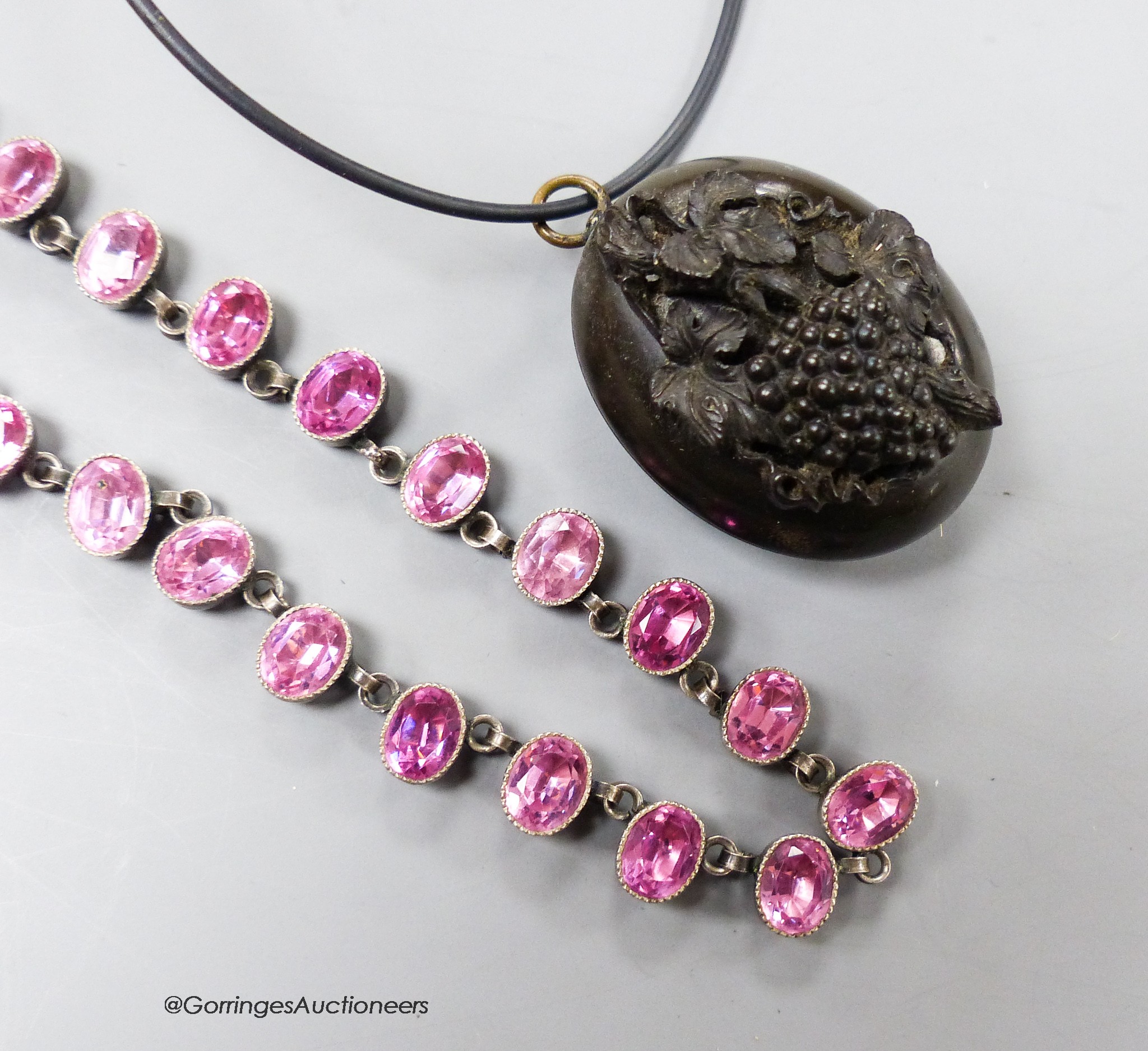 A Victorian jet mourning locket, 35mm, on later necklet and a white metal and pink paste necklace, 37.5cm.